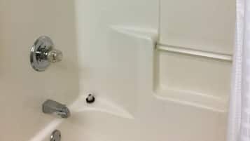 Une baignoire blanche avec un robinet chromé et une pomme de douche.