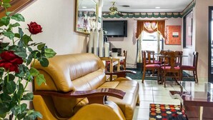 Une chambre d’hôtel avec un canapé, une table à manger avec des chaises, un téléviseur et un escalier.