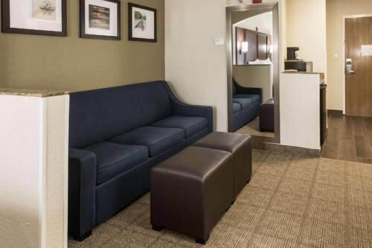 A living room with a sofa, a coffee table, and a carpeted floor.