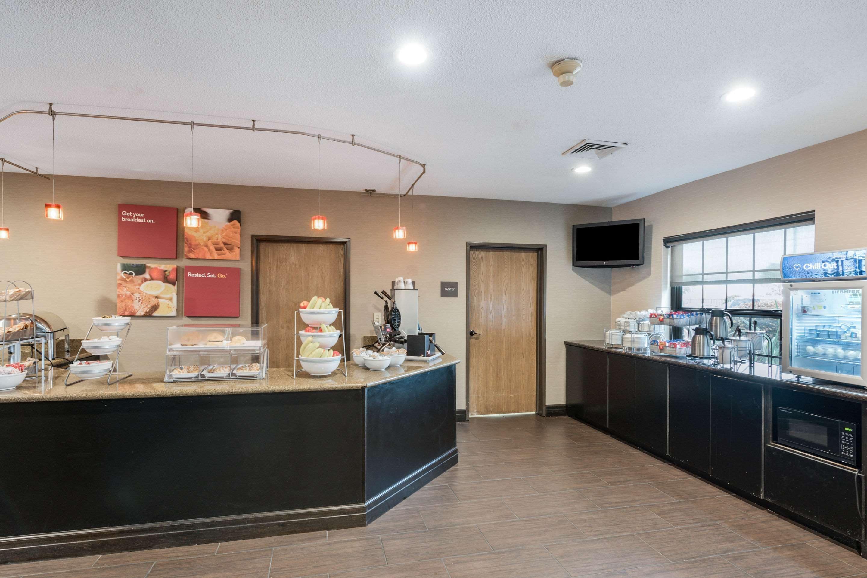 A breakfast bar with various food items and a coffee machine.