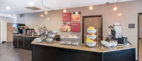 A breakfast bar with various food items and a coffee machine.