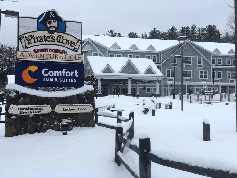 A sign for 'Pirate's Cove Adventure Golf' with a Comfort Inn & Suites sign below it.