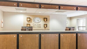 A reception desk with a sign for 'Comfort Suites' and a modern design with wooden panels and recessed lighting. - Comfort Suites at Isle Of Palms Connector (Mount Pleasant)
