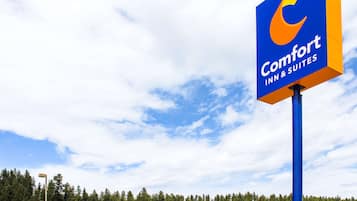 Ein Comfort Inn & Suites Hotel mit einer auffälligen, blau-orangen Signatur, einem Backsteingebäude und einem Parkplatz.