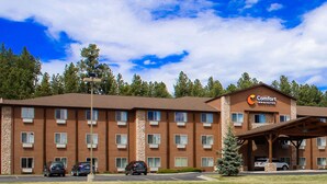 A Comfort Inn & Suites hotel with a stone facade, multiple windows, and a covered entrance.