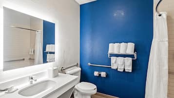 Un baño con un lavamanos blanco, inodoro y una pared de acento azul.