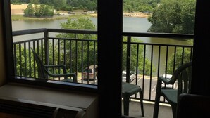 A room with a view of a river, trees, and a distant tower. There are two chairs and a table in the foreground. - Comfort Suites South Park (Colonial Heights)