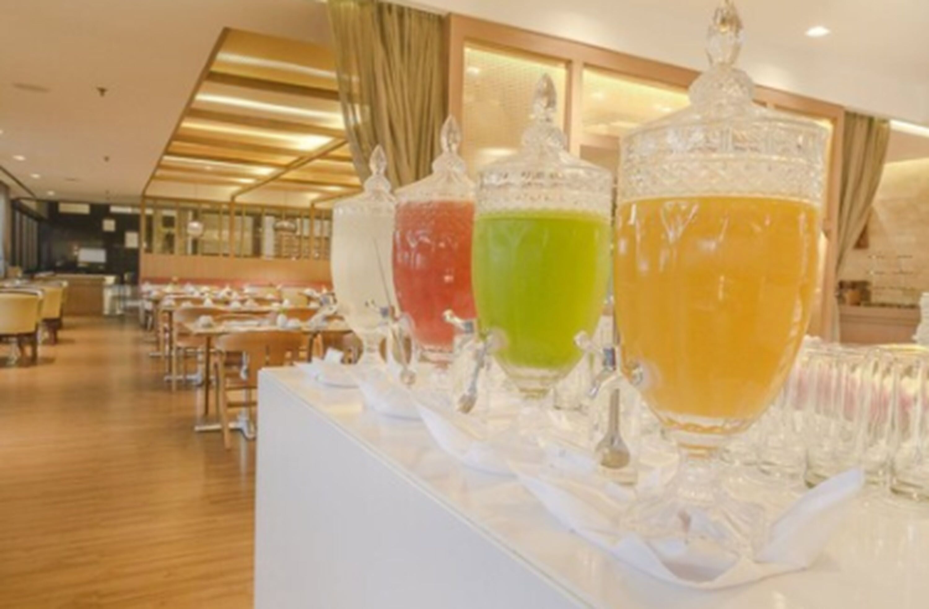 Un vestíbulo de hotel con una larga recepción, varias zonas de estar y una decoración de estilo moderno.