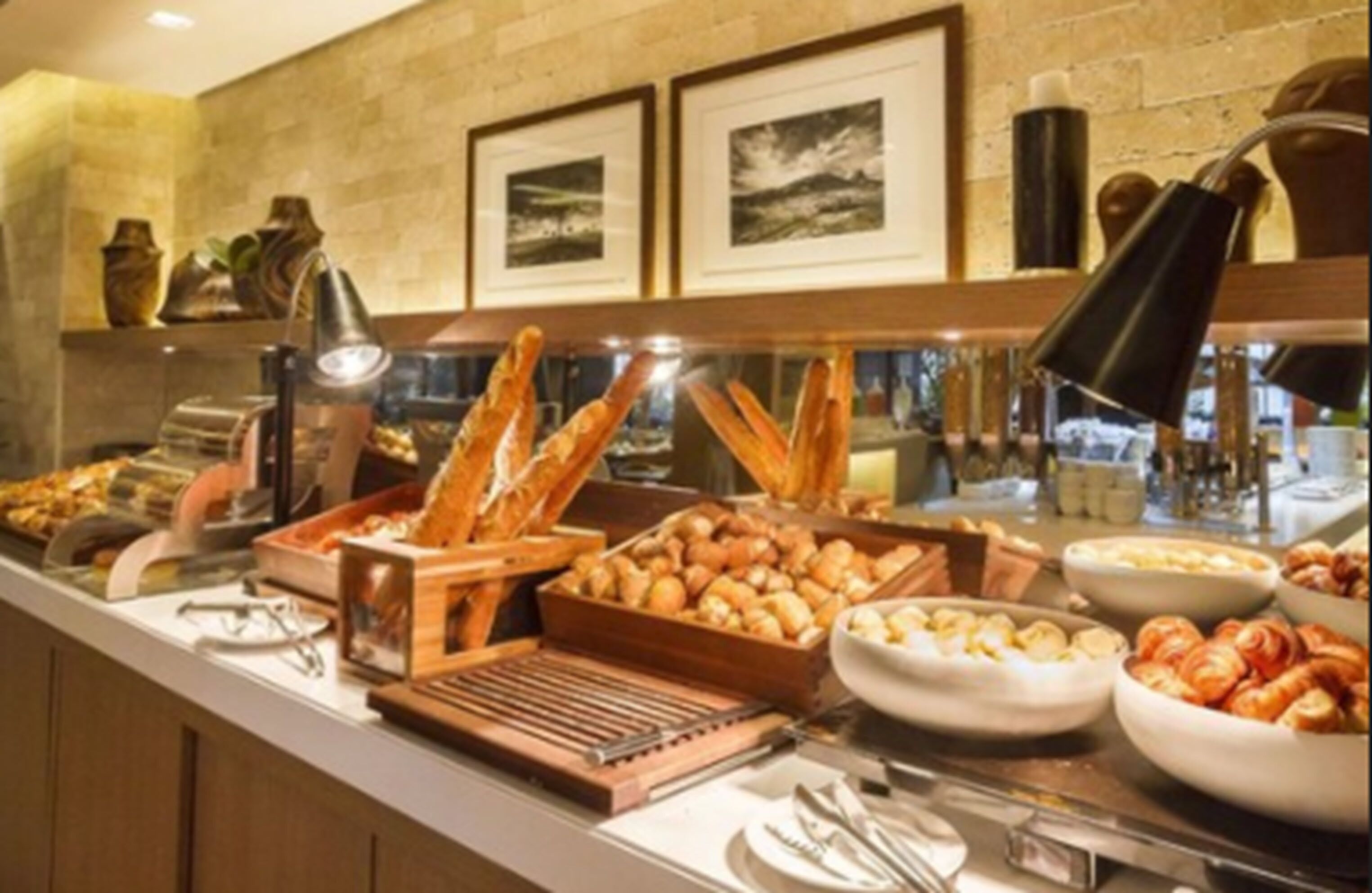 A buffet with various food items, including bread, pastries, and fruits.