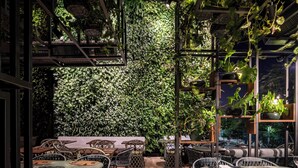 An indoor dining area with wooden flooring, wicker chairs, and tables. There is a large green wall with plants and a ceiling with hanging plants. - Hotel Gran Marquise (Fortaleza)