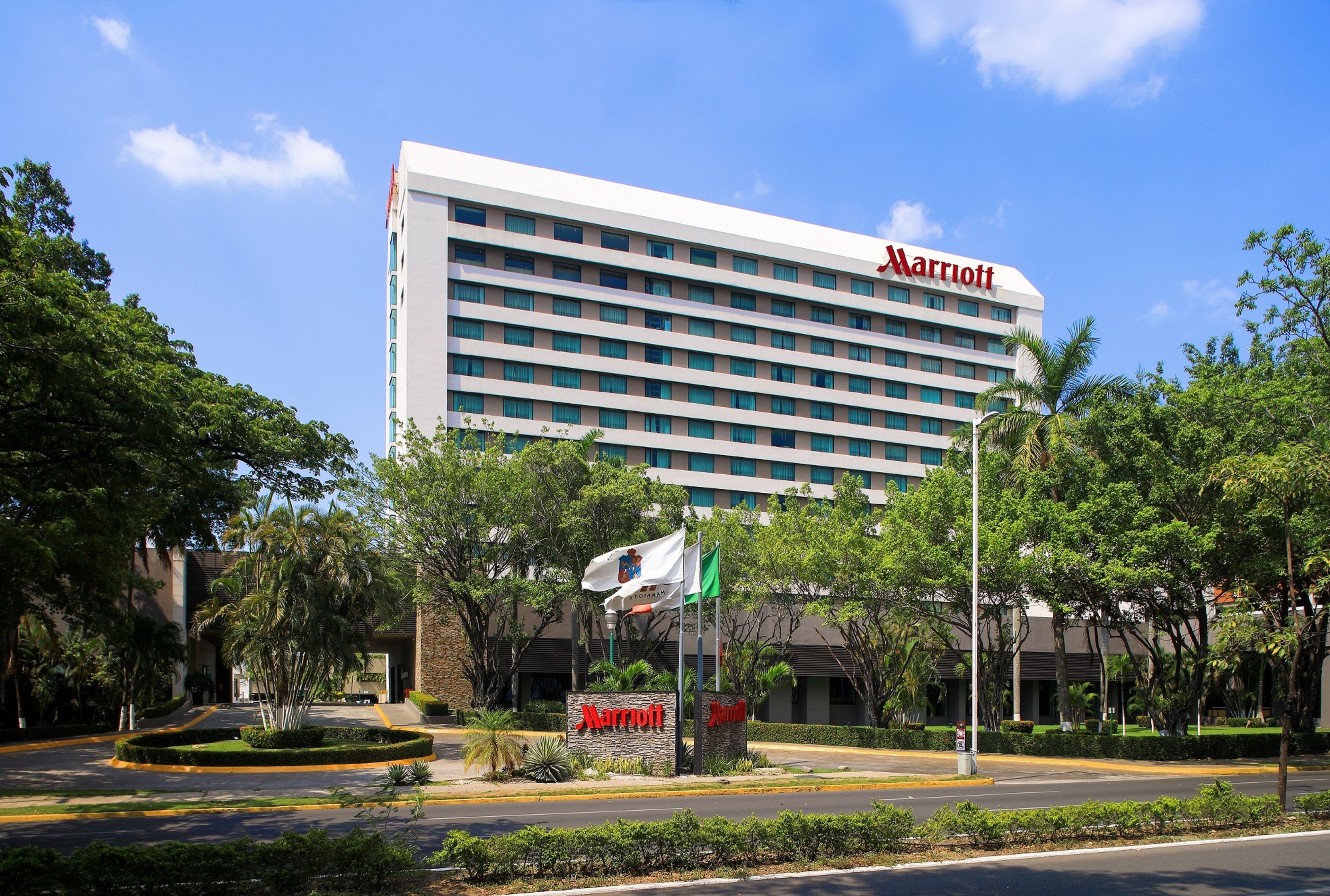 A Marriott hotel with a modern design, featuring a large building with multiple floors and a prominent 'Marriott' sign.