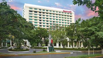 Een Marriott hotel met een modern design, omgeven door weelderige begroeiing en een aangelegde tuin.