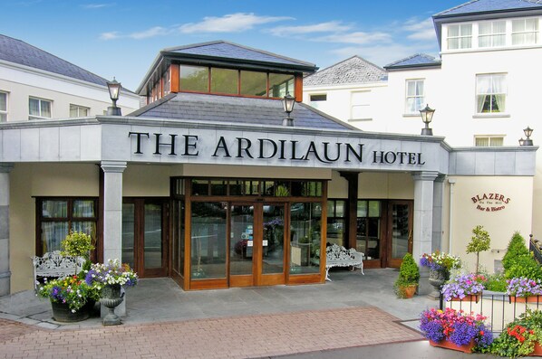 The Ardilaun Hotel with a prominent entrance, large glass doors, and a well-maintained flower bed in front. - The Ardilaun Hotel (Galway)