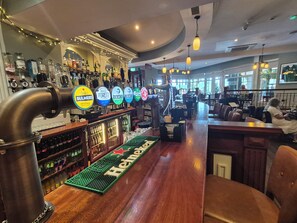 Eine Bar mit einer Zapfsäule für Bier, gekennzeichnet mit 'Heineken', sowie verschiedenen anderen Biersorten.