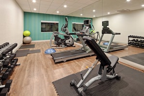 A gym with treadmills, elliptical machines, and free weights.