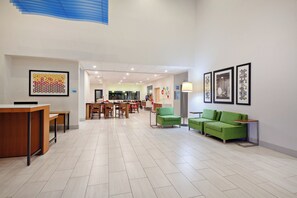 A spacious lobby with a reception desk, seating area, and a dining space.