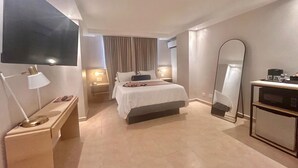 A hotel room with a bed, bedside lamps, a TV, a bedside table, a mirror, and a desk with a computer. - Best Western El Dorado Panama Hotel (Panama City)
