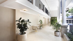 A spacious indoor area with a high ceiling, potted plants, and a seating arrangement. - Best Western El Dorado Panama Hotel (Panama City)