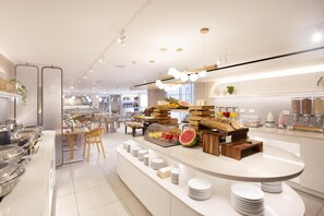 Un área de buffet moderna y bien iluminada, con diversos alimentos y platos ordenados.