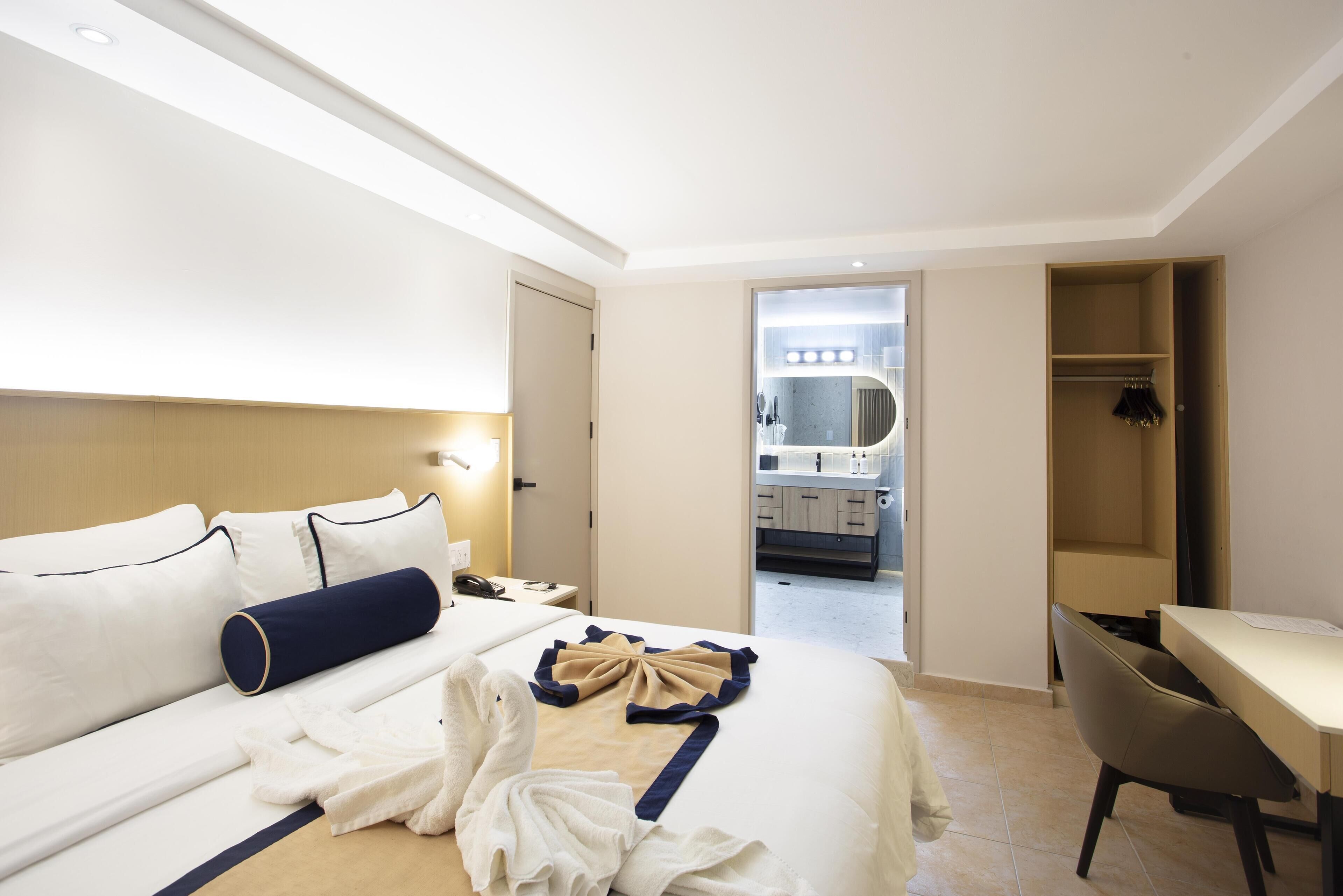 Ein Hotelzimmer mit Bett, Nachttisch und Schreibtisch.