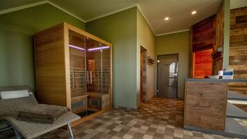Ein Zimmer mit Schachbrettfußboden, einem Holzschrank, einem Korbstuhl und einem kleinen runden Tisch.