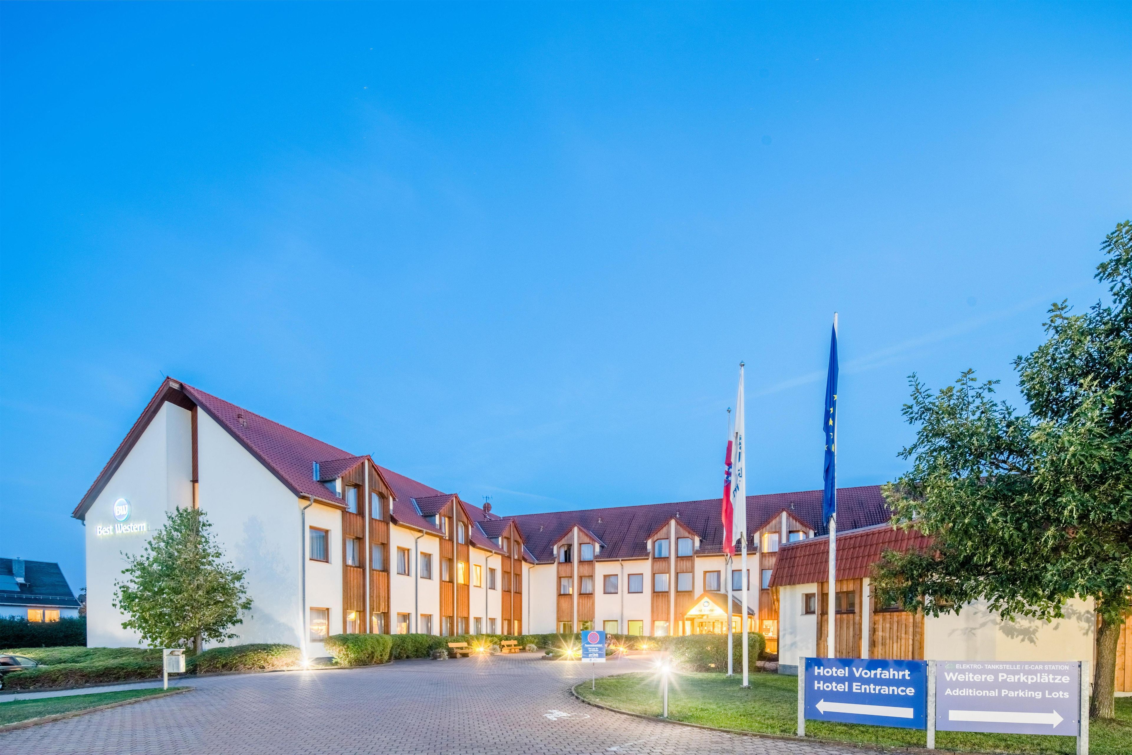 A hotel with a modern design, featuring a central courtyard, multiple buildings, and a flagpole.