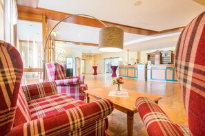A hotel lobby with plaid-patterned seating, a reception desk, and a chandelier. - Best Western Hotel Erfurt-Apfelstaedt (Nesse-Apfelstädt)