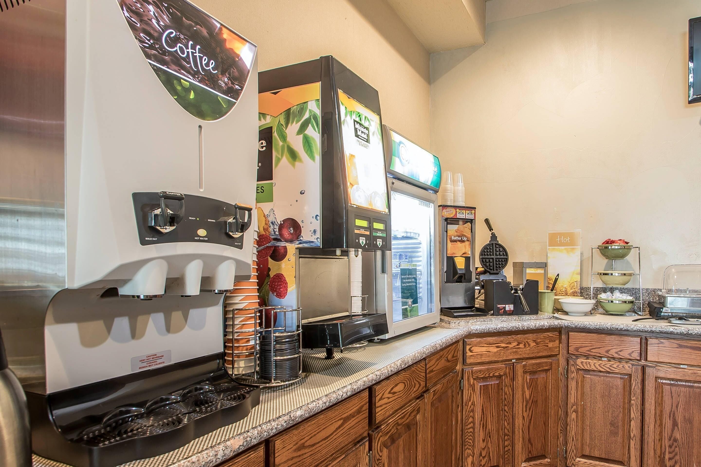 A coffee station with a coffee machine, a water dispenser, and a beverage dispenser.