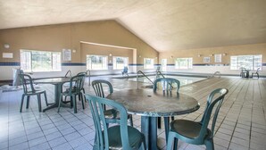 A large indoor swimming pool with multiple lanes, surrounded by chairs and tables, and large windows along the walls. - Quality Inn & Suites East Troy I-43 (East Troy)