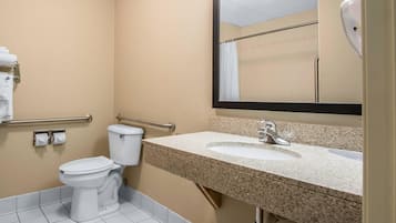 A bathroom with a toilet, a sink, a mirror, and a towel rack.