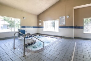 Un cuarto de spa con hidromasaje, una ventana y un letrero de advertencia en la pared.