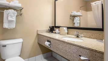 A bathroom with a toilet, sink, and mirror.