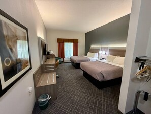 A hotel room with two beds, a desk, a television, and a trash bin. - Quality Inn & Suites East Troy I-43 (East Troy)