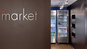 A modern interior with a sign reading "the market" and two refrigerated display cases.