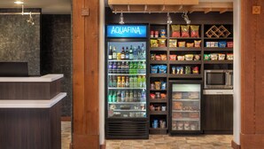 A self-service kiosk area with a refrigerated drink dispenser, snack vending machines, and a microwave. - Courtyard by Marriott Farmington (Farmington)