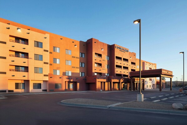 A multi-story hotel with a modern design, featuring a prominent entrance and a parking area in front. - Courtyard by Marriott Farmington (Farmington)
