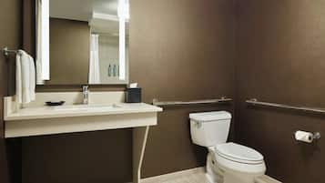 A modern bathroom with a white sink, mirror, and toilet.