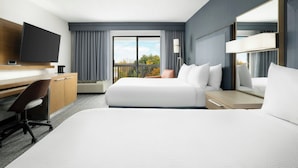A hotel room with a bed, desk, chair, TV, and a balcony with a view. - Courtyard by Marriott Concord (Concord)