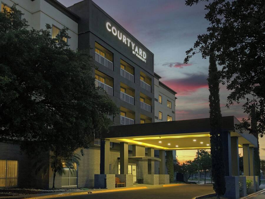 Een Courtyard by Marriott hotel met een modern design, met een overdekte entree en meerdere balkons.