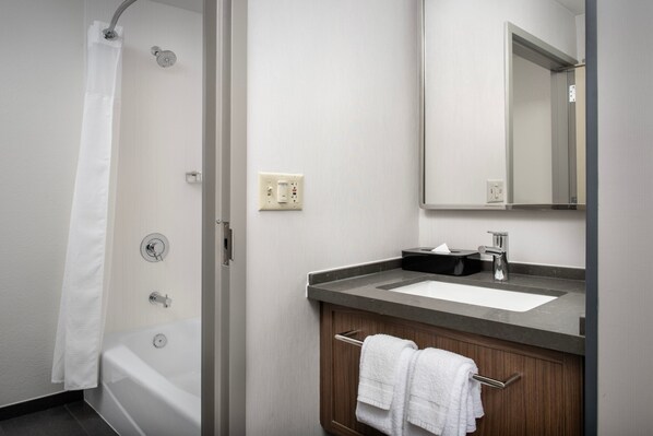 A modern bathroom with a bathtub, a sink, and a mirror.
