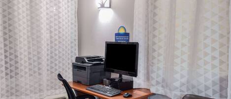 Une chambre d’hôtel équipée d’un bureau, d’un ordinateur, d’une imprimante et d’un appareil de climatisation.