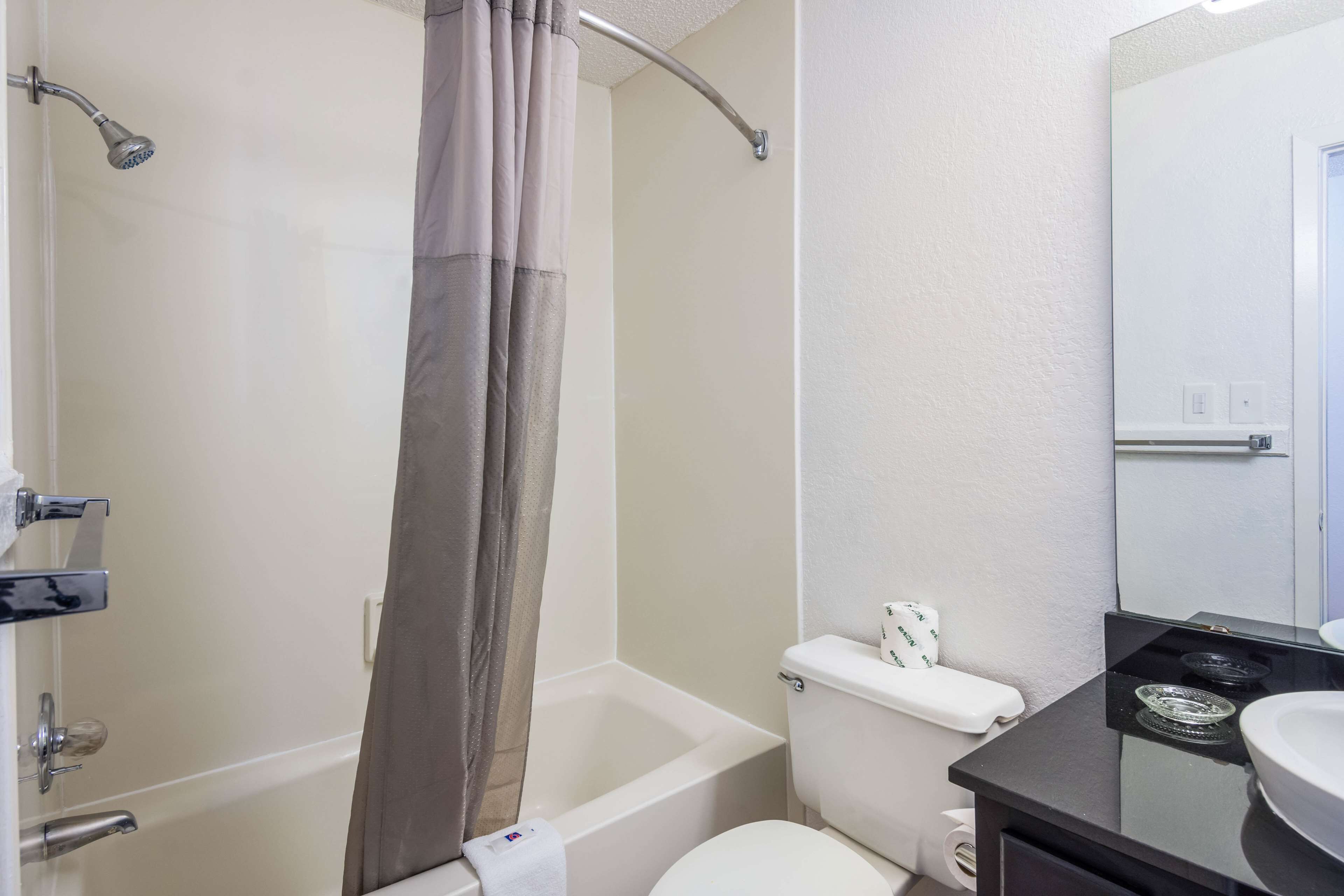 A bathroom with a bathtub, toilet, and a sink.