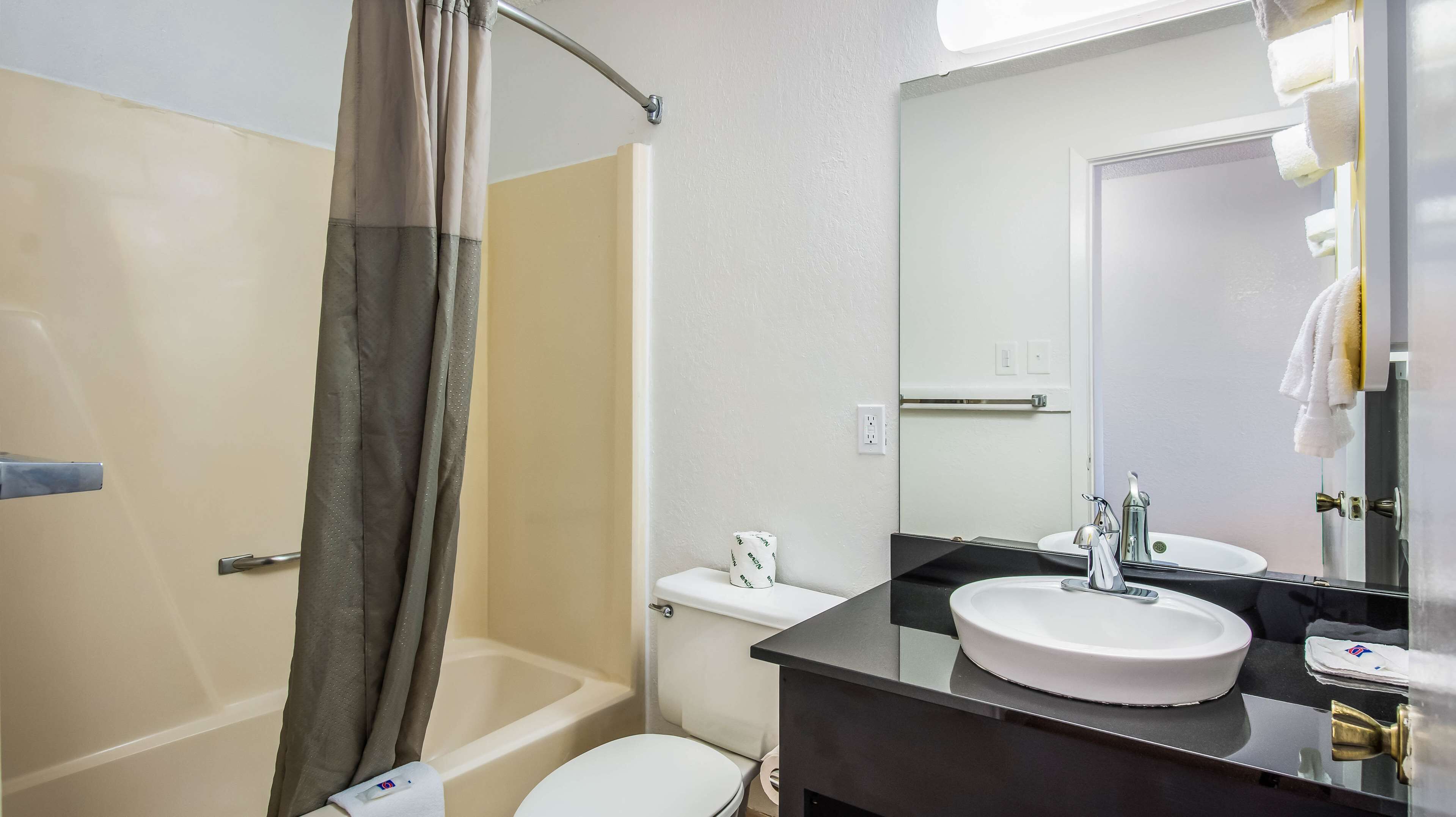 A bathroom with a bathtub, toilet, and sink.