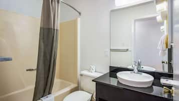 A bathroom with a bathtub, toilet, and sink.