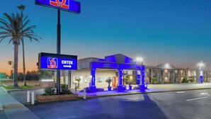 A 6 Suites hotel with a clear entrance sign, outdoor seating area, and a well-lit facade. - Studio 6 Suites Madera, California - Yosemite (Madera)