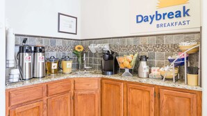 A kitchen with a Daybreak Breakfast sign, stainless steel appliances, and a tiled backsplash. - Days Inn by Wyndham Kimball (Kimball)