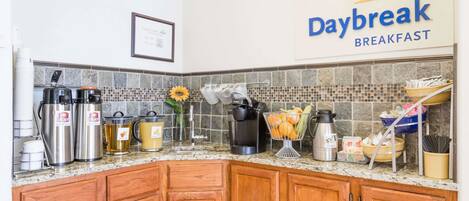 Una cocina con un letrero de Daybreak Breakfast, electrodomésticos de acero inoxidable y salpicadero de azulejos.