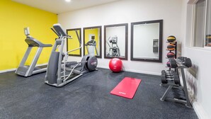 A gym with treadmills, elliptical machines, a red mat, a red exercise ball, and a set of dumbbells. - Days Inn by Wyndham Kimball (Kimball)