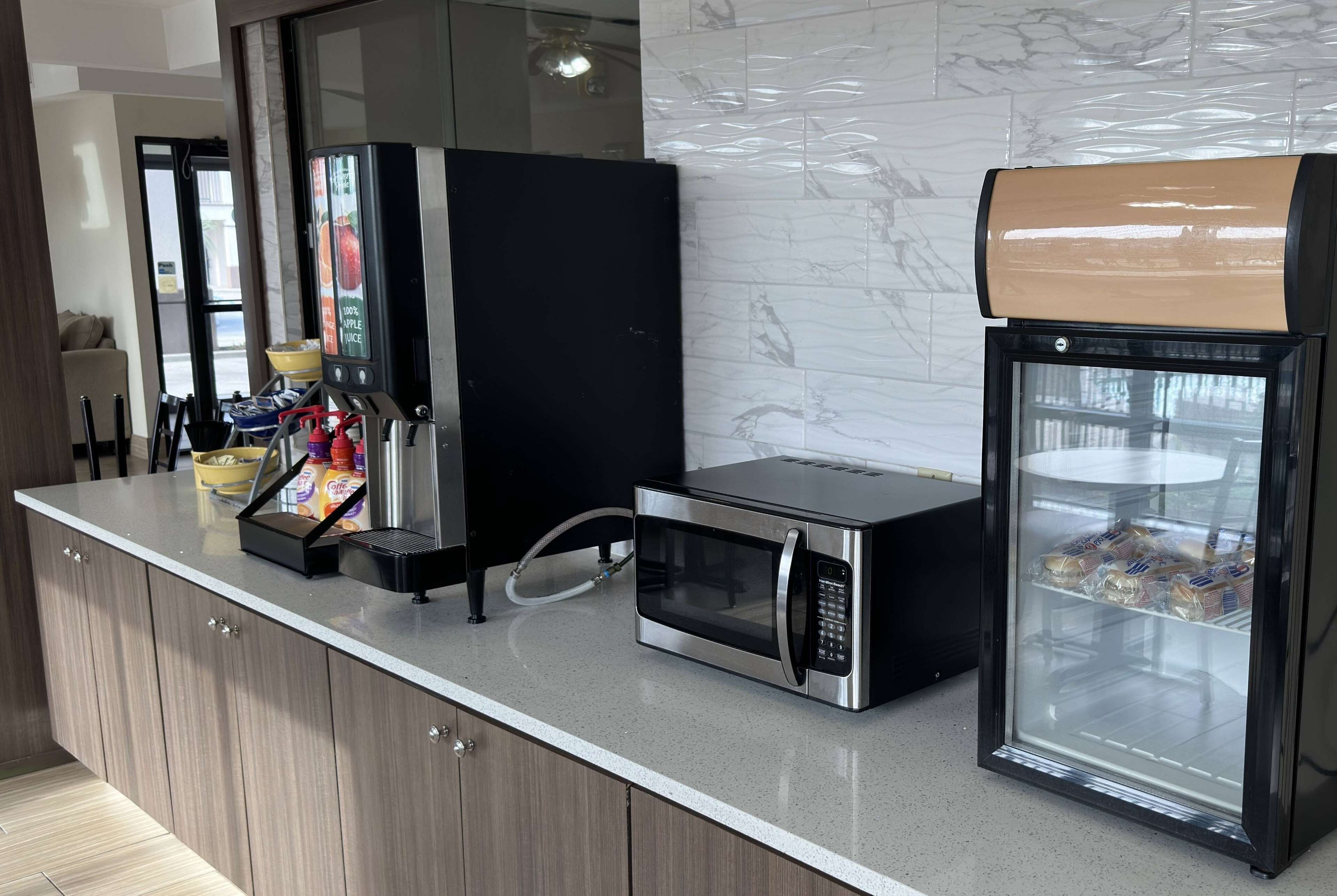 Eine Küchenzeile mit Kaffeemaschine, Mikrowelle und Broitauslage.