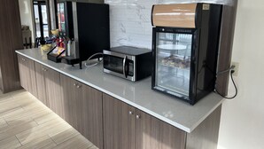 A kitchenette with a microwave, coffee machine, and a mini-fridge. - Days Inn & Suites by Wyndham Opelousas (Opelousas)
